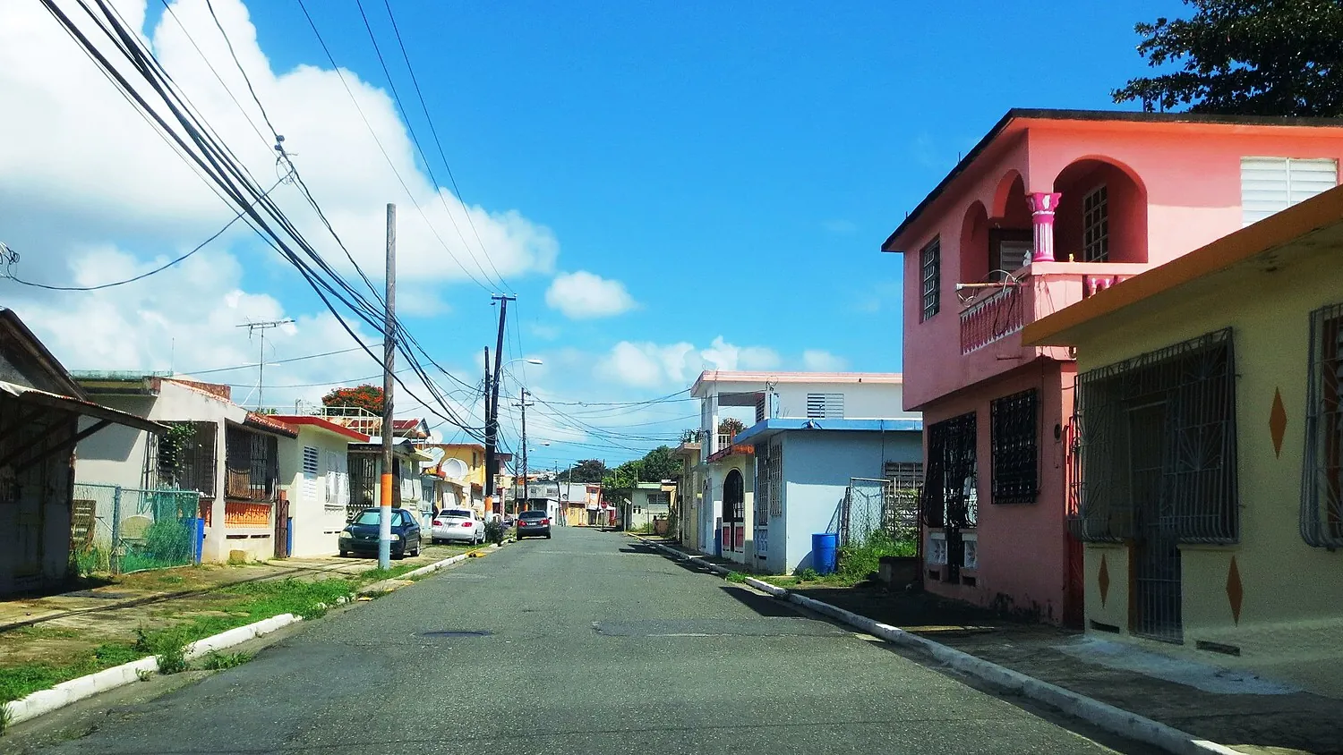 Calle de un barrio de Naguabo, Puerto Rico, con casas de cemento y rejas